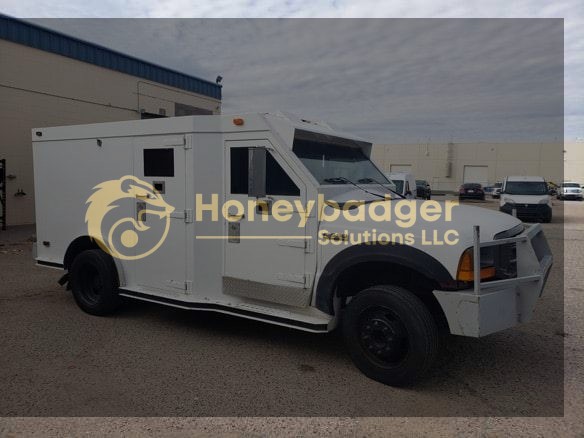 Armored vehicle designed for secure transportation, featuring a white exterior and multiple access points.