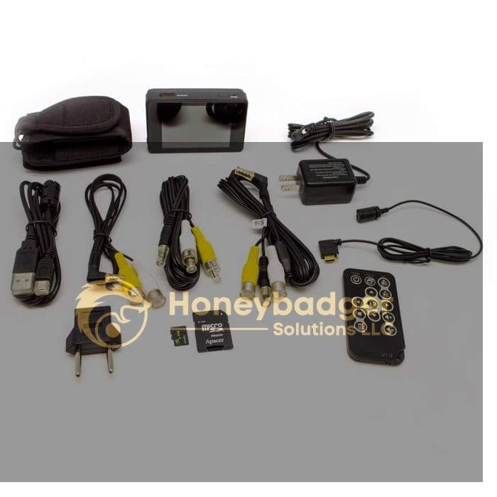 LawMate Surveillance Kit including a compact device, cables, power adapter, remote control, SD card, USB charger plug, and carrying case.