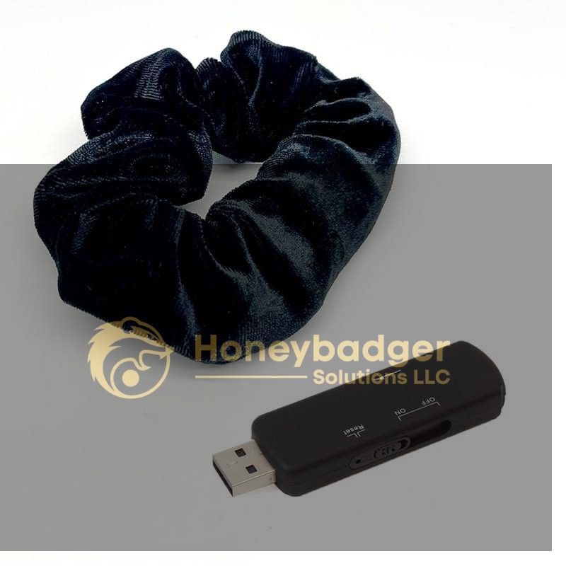 A navy blue velvet hair tie and a black USB flash drive placed side by side on a white background.