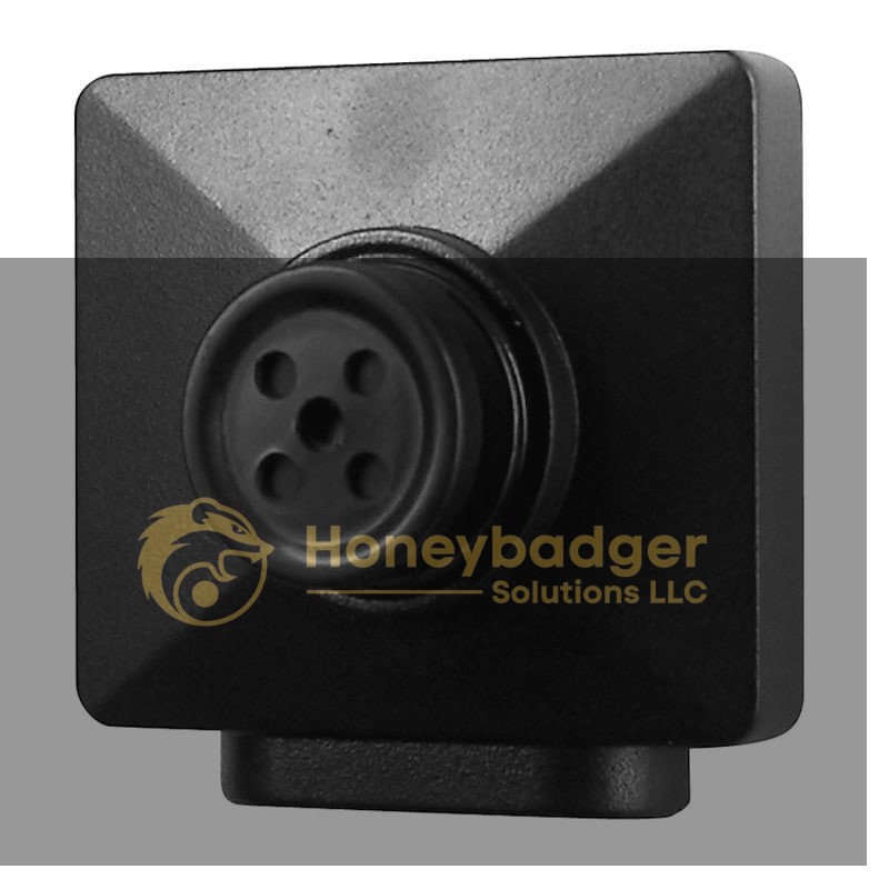 A compact black surveillance camera with a square design and a button-shaped lens for discreet monitoring.