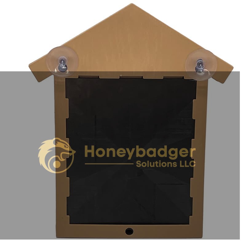 Wooden bird house with a house shape, black rectangular center, and two suction cups at the top corners.