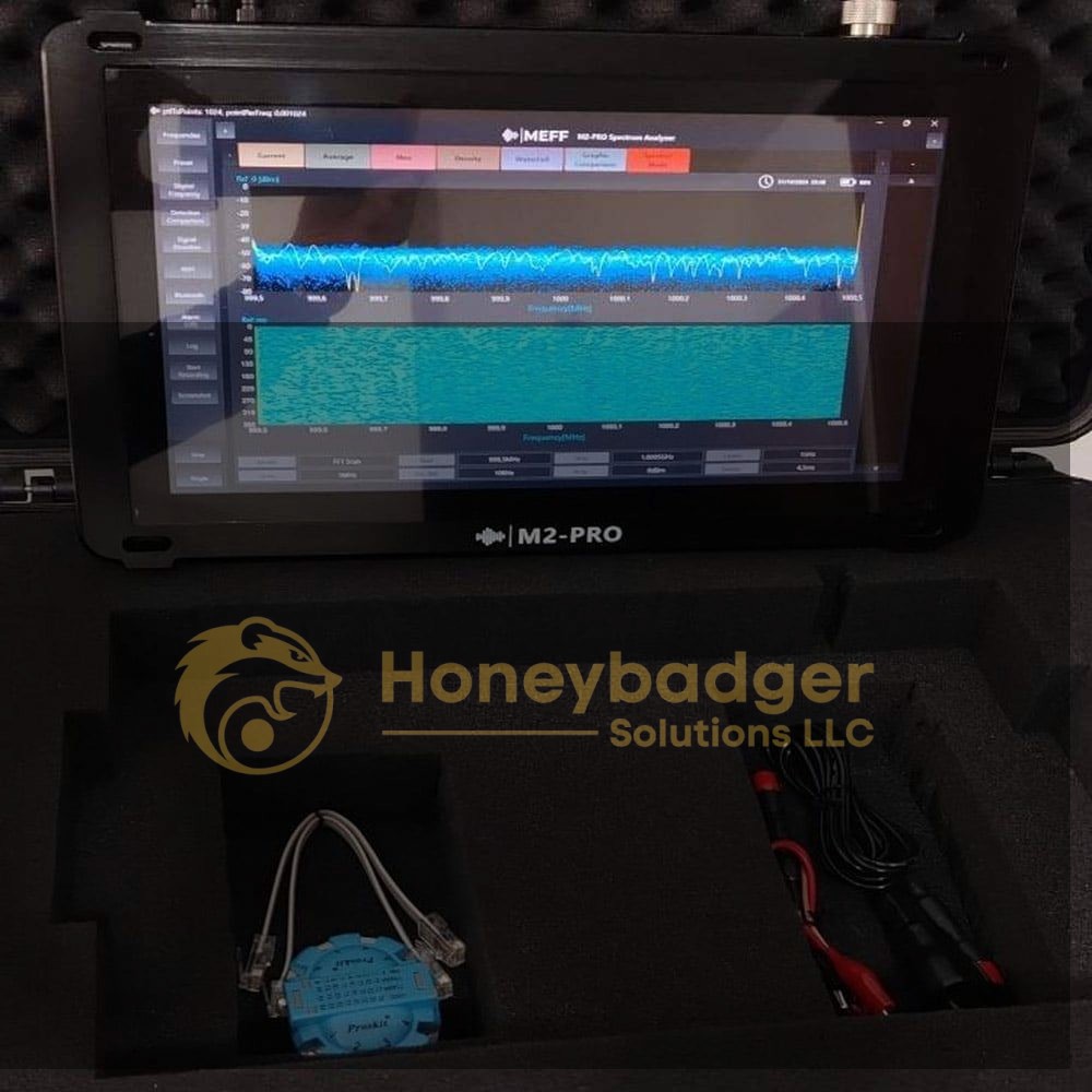M2-PRO Spectrum Analyzer displaying a blue waveform spectrum on its screen, set in a foam case with cables and a blue sensor component.