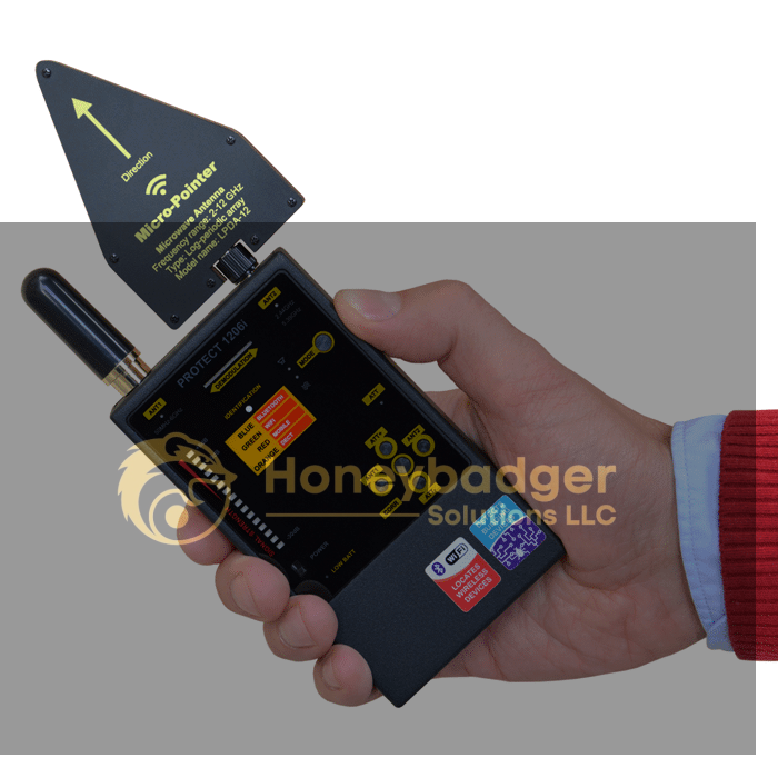 A hand holds the MicroPointer detection device, displaying various indicators and buttons on its screen.