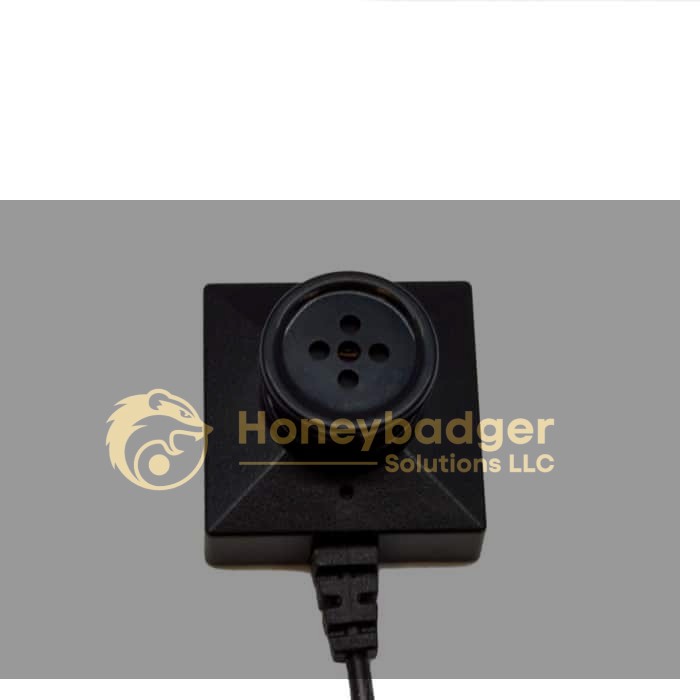 A compact black surveillance camera disguised as a button, mounted on a square base with a bottom cable.