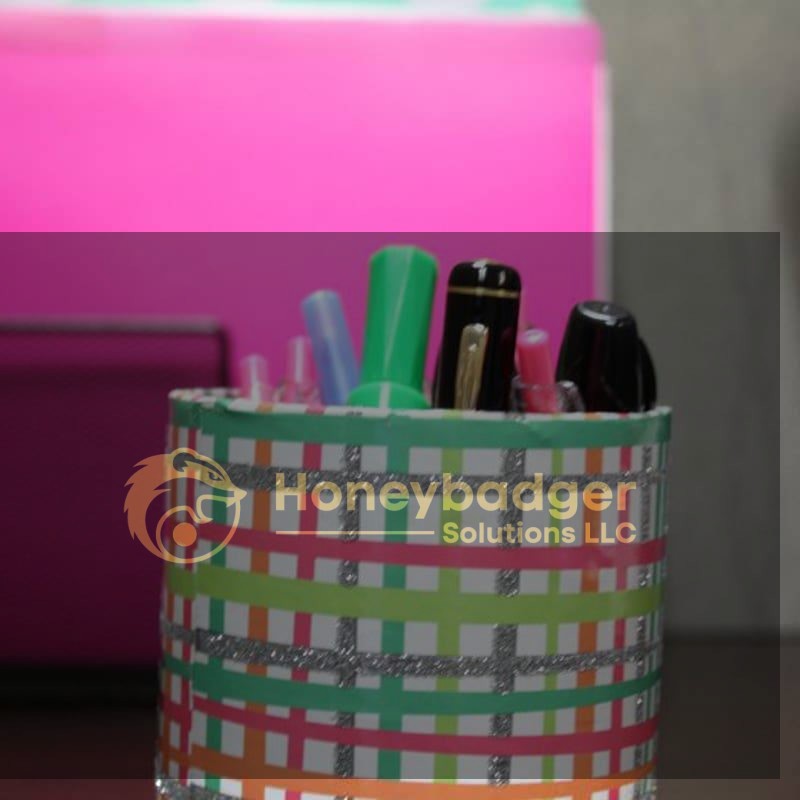A colorful pen holder filled with various writing instruments, including pens and markers, on a desk.