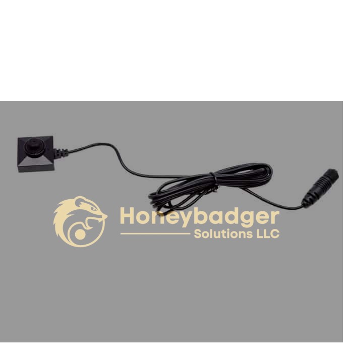 A compact, square black button camera with a central lens and a long black cable with a connector, coiled neatly.