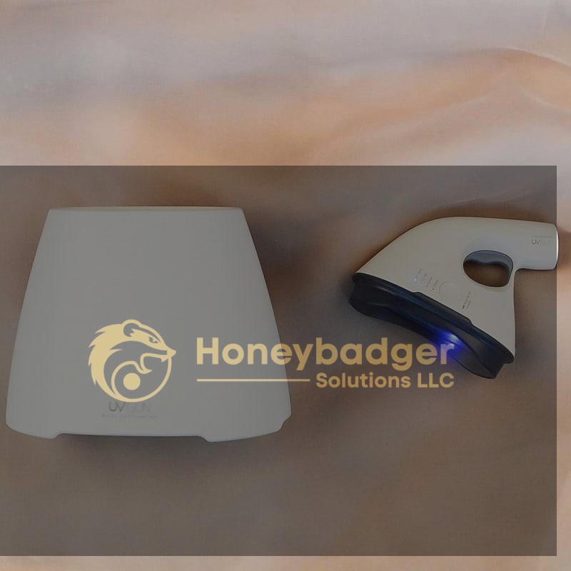 A UV Sanitizer Gun with a glowing blue light next to its white charging base on a soft beige surface.