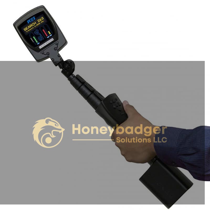 A person holding the ORION 2.4 Non-Linear Junction Detector with a digital display and indicators.