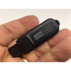 A hand holding a black USB memory stick with a retractable connector and USB MEMORY label.