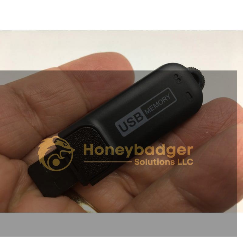 A hand holding a black USB memory stick with a retractable connector and USB MEMORY label.