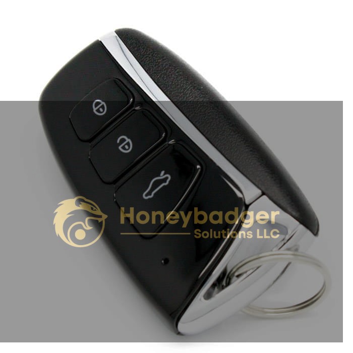 A black and silver key fob featuring three functional buttons and a keyring attachment.