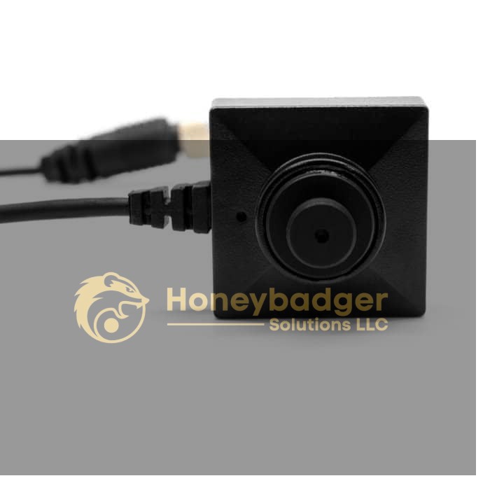 Compact black square LawMate Wi-Fi Smartphone Camera with a central round lens and a connected black cable.