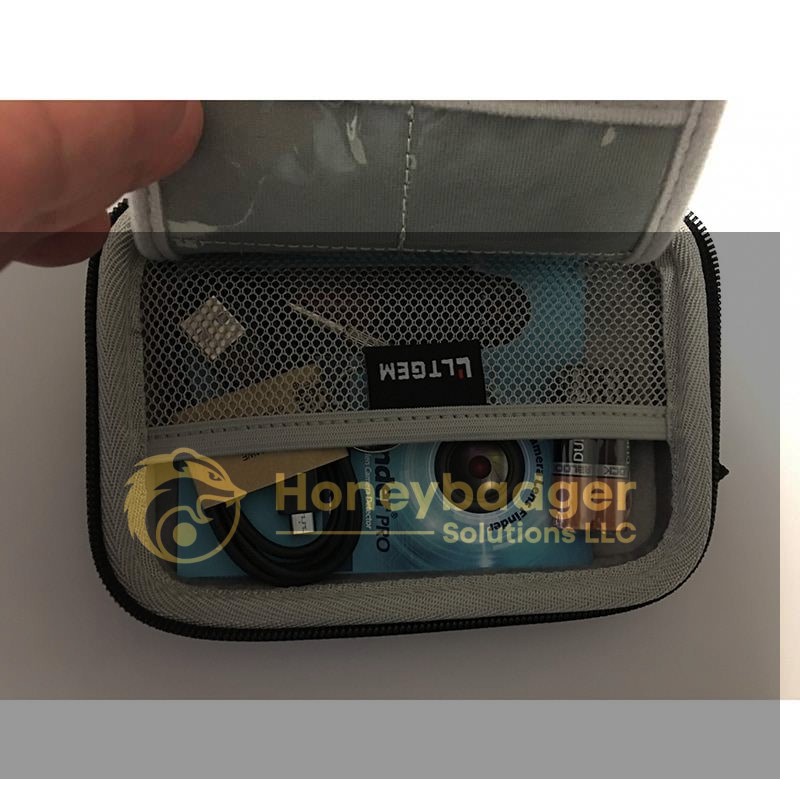 A gray Road Warrior Kit pouch opened to reveal mesh pockets containing a USB cable, AA batteries, an SD card, and a Finder Pro CD.