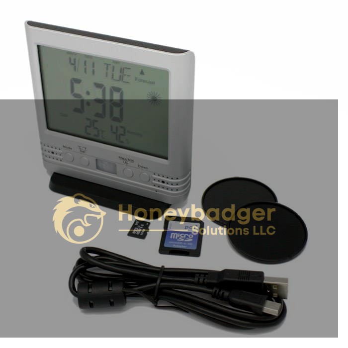 Digital desk clock displaying time and weather, accompanied by USB cable, SD card, microSD card, and two circular bases.