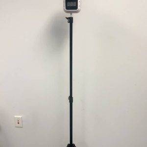 An adjustable black tripod stand with a digital display mounted on top, set against a plain background.