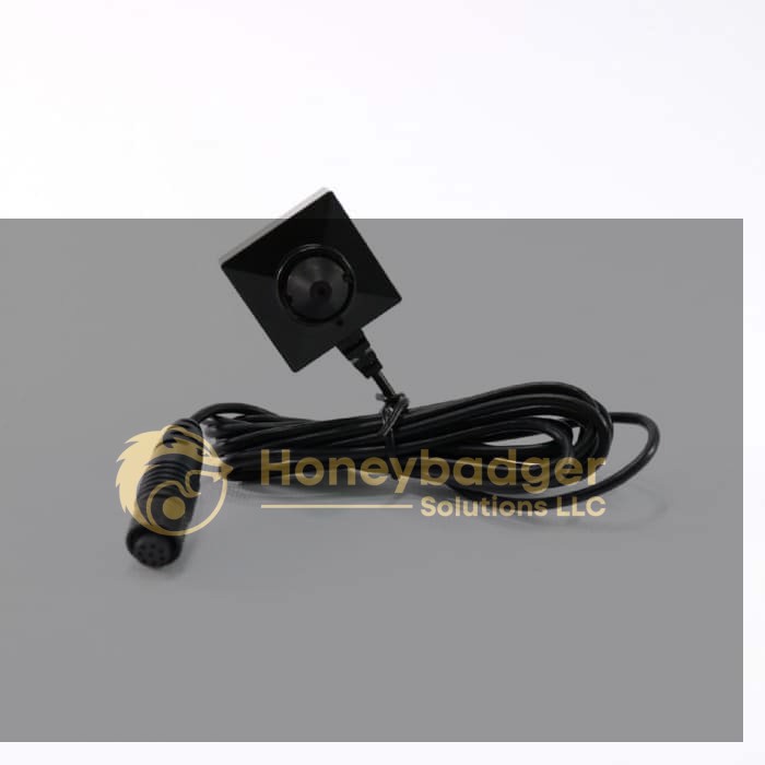 A compact black security camera with a square design and a central lens attached to a long black cable with a round connector.