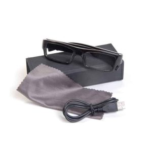 Stylish glasses DVR camera placed on a black box with a gray cleaning cloth and USB cable.