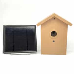SG Xtreme Life Bird House in tan color with a round lens, accompanied by a black solar panel on a white background.