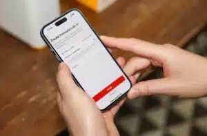 A person using a smartphone to set up a Firewalla Wi-Fi network with options for network name and password.