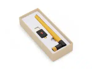 A yellow stylus and a black USB adapter arranged in a beige presentation box with white padding.
