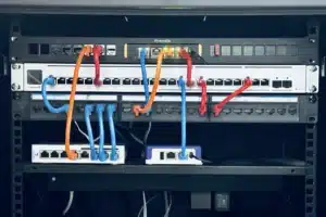Firewalla Gold Rack Mount with multiple network switches and Ethernet cables in blue, orange, and red.