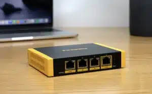 Firewalla Gold SE, a compact black and yellow multi-gigabit cybersecurity firewall and router with four Ethernet ports.