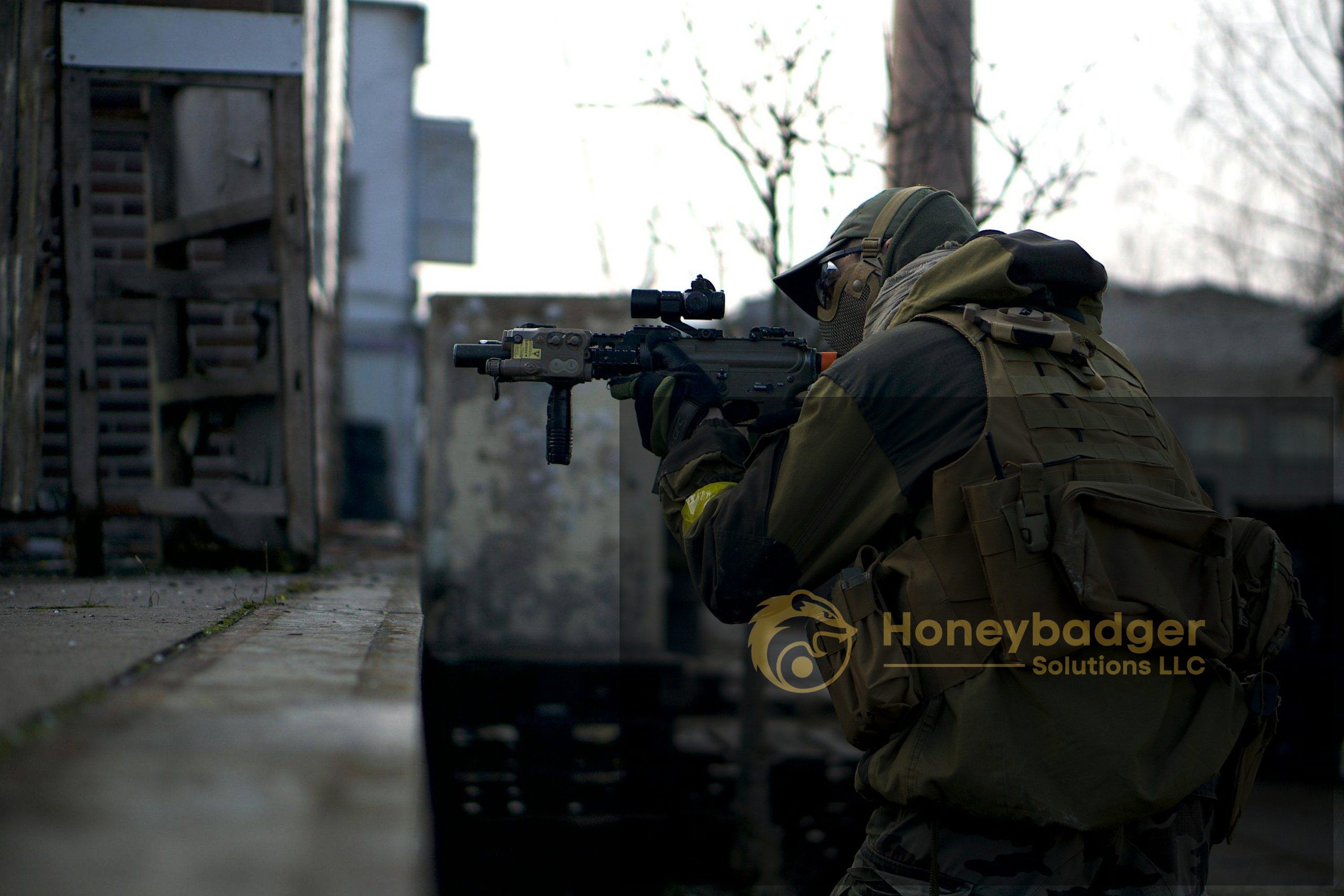 A private investigator in tactical military gear aims a rifle while positioned near a concrete structure.