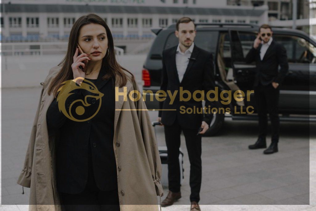 Businesswoman in a beige coat talking on a phone, accompanied by two security personnel in suits.