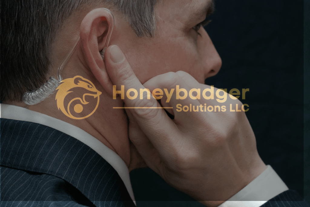 Man wearing a suit with an earpiece, touching his ear with one hand.