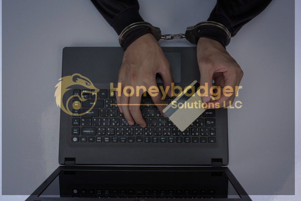 Hands in handcuffs holding a credit card above a laptop keyboard, suggesting fraudulent activity.
