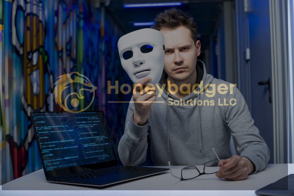 Individual in a gray hoodie holding a white mask while sitting at a laptop with code displayed on the screen.