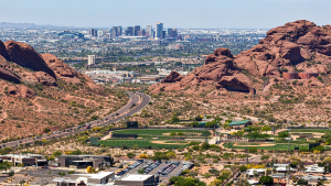 A panoramic view of Arizona featuring desert terrain and a distant city skyline.