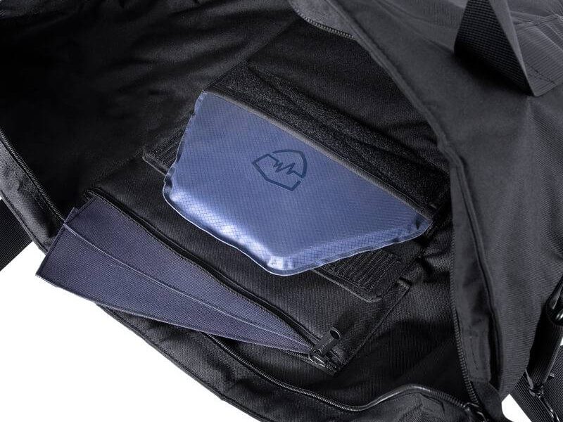 A black Body Armor Bag lies open to reveal padded compartments, a zip pocket, and a blue protective insert inside the gear carrier on a white background.