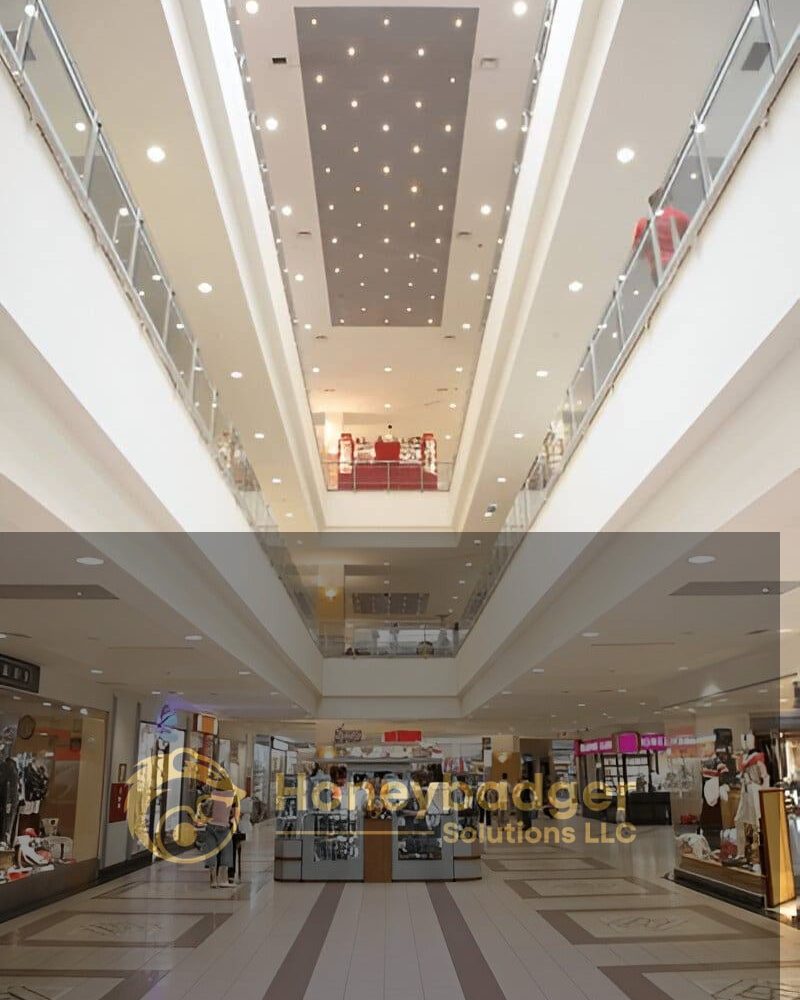 Interior view of a spacious shopping mall with multiple levels, glass railings, and various storefronts.